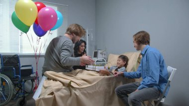 Yan görüş, akrabalar hastanede yatağında yatan kıza bir hediye verir.