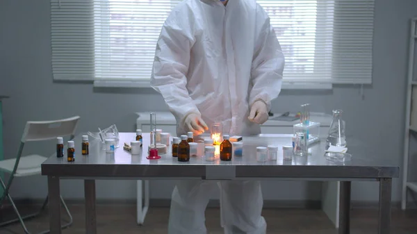 Человек в защитной рабочей одежде поджег вещества в лаборатории — стоковое фото
