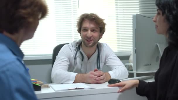 Доктор дає інструкції і зразок чашки хлопчикові в кабінеті лікарні — стокове відео
