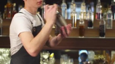 Barmen bardaki bardağı alkolle sallar, kapatır.