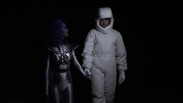 Alien con piel azul va con astronauta en la oscuridad — Foto de Stock