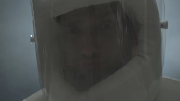 En astronaut i en rymddräkt ler och gör ansikten — Stockfoto