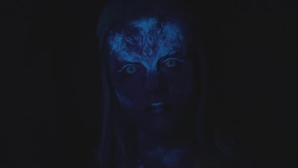 A ragyogó kék arcú nő a kamerába néz. — Stock videók