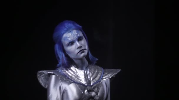 Alien con el pelo azul está de pie y buscando en algún lugar — Vídeo de stock