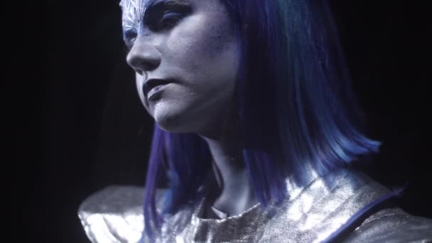 De perto, alienígena com cabelo azul está de pé e olhando em algum lugar — Vídeo de Stock