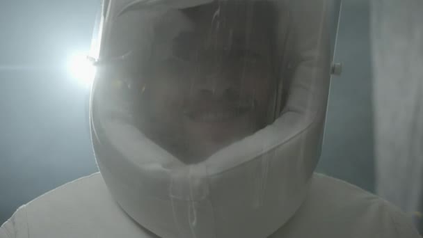 Een astronaut in een ruimtepak kijkt naar de camera en glimlacht — Stockvideo