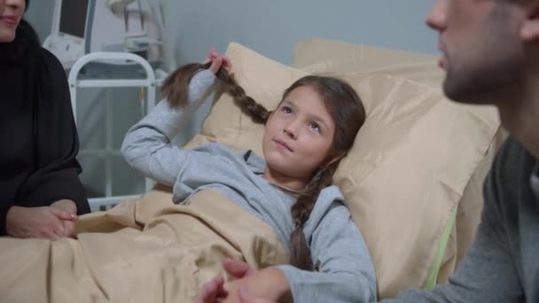 Relatives come to visit and to talk to girl who lie on the bed in the hospital — 图库视频影像