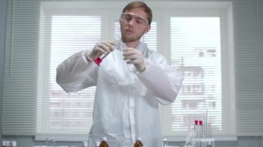 Koruyucu iş kıyafetleri ve eldivenler bilim adamı laboratuara bir şey döktü.