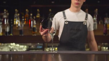 Barmen barda bardağa şampanya dolduruyor.