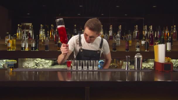 Barman giet alcohol in shotglaasjes een voor een — Stockvideo