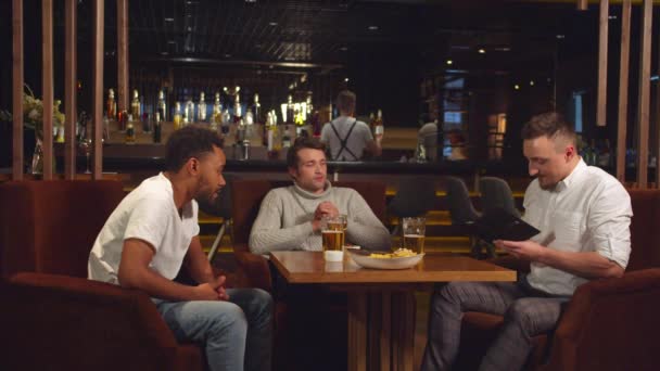 Friends sit at the bar, they put money in a bill one by one — Stok video