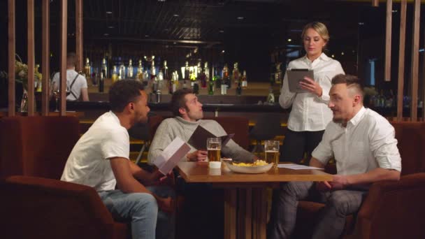 Официант принимает заказ на планшете у друзей — стоковое видео