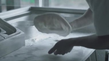 Şef pizza için hamur hazırlıyor.