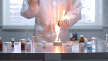 Koruyucu iş kıyafetli bir adam laboratuvardaki o şeyi ağır çekimde yaktı.