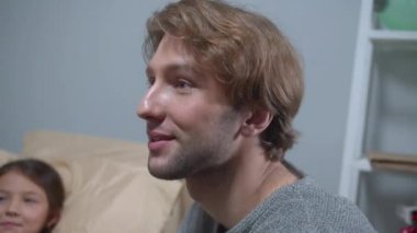 Genç adam gülümse ve hastanede yatakta yatan kızla konuş.