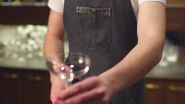 Barman zet ijs in leeg glas aan de bar, slow motion — Stockvideo