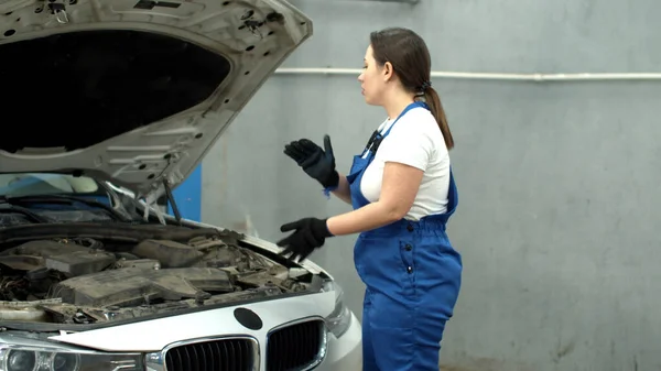 Woman mechanic repairs a car in car service — Stockfoto