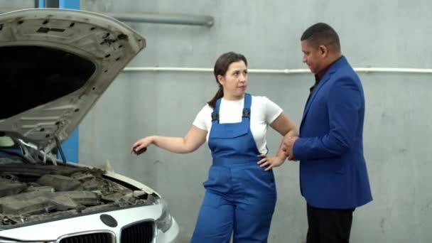 Mechanik rozmawia z właścicielem i daje kluczyki do samochodu — Wideo stockowe
