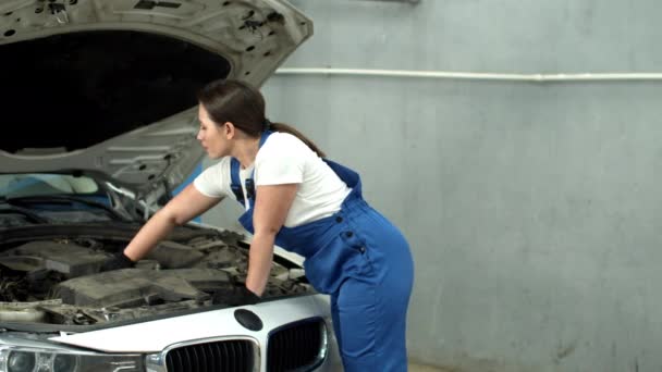 Mujer mecánico repara un coche en el servicio de coches — Vídeo de stock