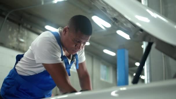 Técnico en reparaciones uniformes del coche en taller de reparación de automóviles — Vídeos de Stock