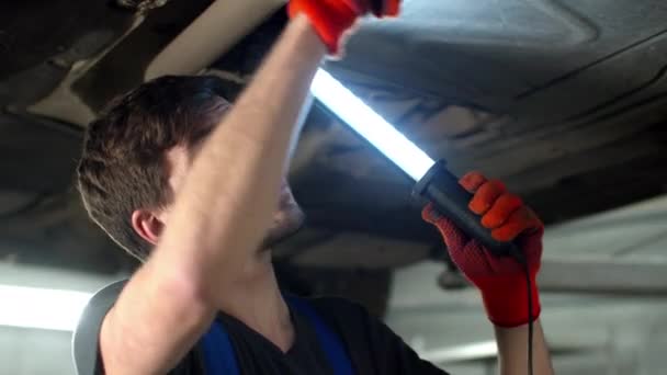 Mécanicien avec lampe de poche répare une voiture, gros plan — Video