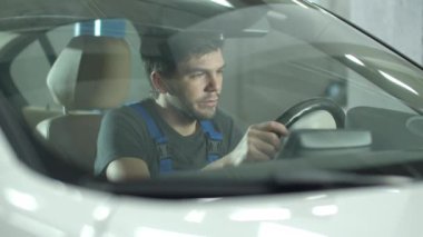 Mechanic sits in a car and imagines that car is his