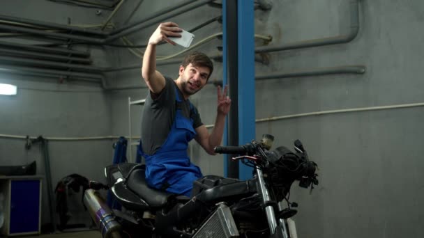 Техник садится на мотоцикл и делает фото — стоковое видео