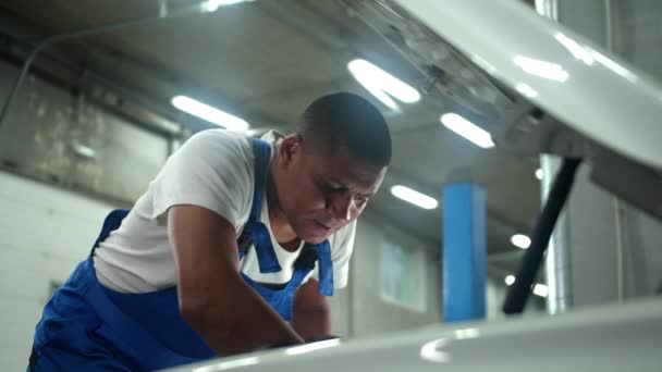 Mecânico em reparação uniforme do motor do carro — Vídeo de Stock