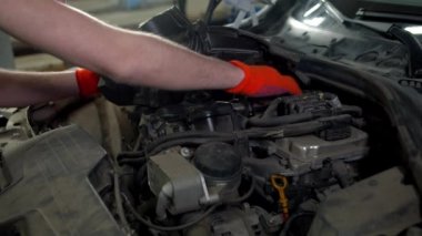 Tamirci arabanın motorunu kontrol eder, kapatır.
