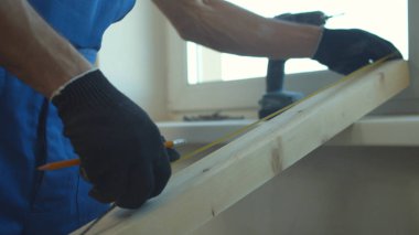 Mimar tahtanın uzunluğunu ölçer