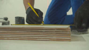 Yaklaş, insan bir fayans uzunluğu ölçer.