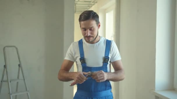 Builder stands and looks at the instrument — Stock Video