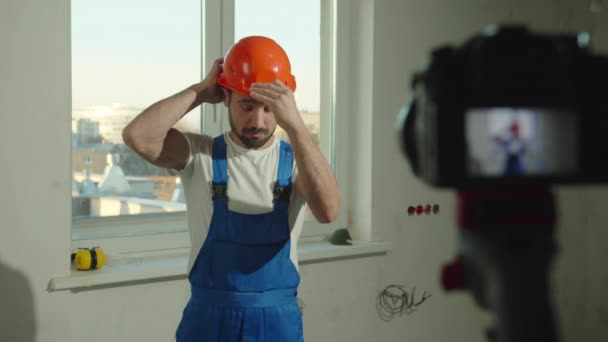 Slow motion, builder puts on helmet and talks on camera — Stock Video