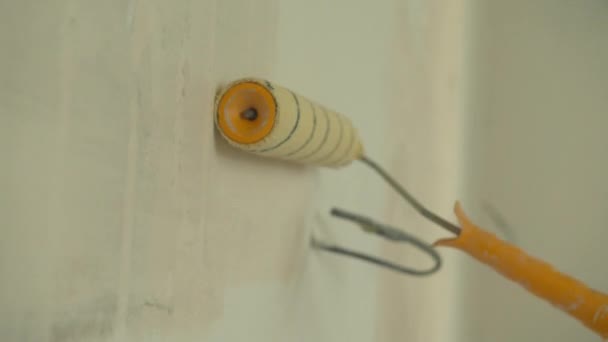 Κοντινό πλάνο, επισκευαστής ζωγραφίζει έναν τοίχο στο διαμέρισμα — Αρχείο Βίντεο