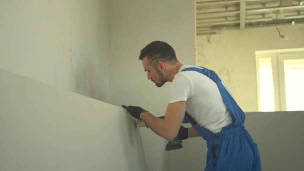 Reparador hace un agujero en la pared — Vídeo de stock