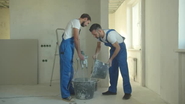 Construtores em trabalho uniforme com misturador de cimento — Vídeo de Stock