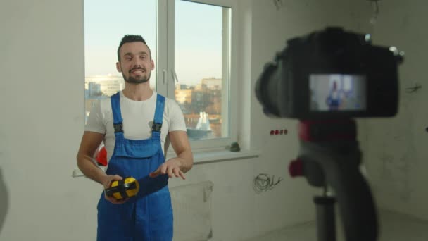 Bauarbeiter steht vor der Kamera und spricht über Kopfhörer — Stockvideo