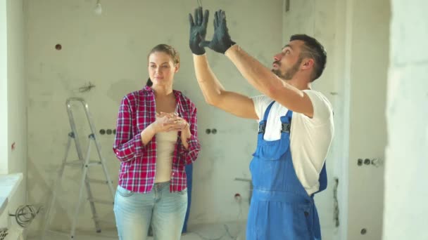 Construtor mostra um reparo para uma mulher — Vídeo de Stock