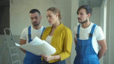 Kadın, tamircilere bir iş planı açıklıyor.