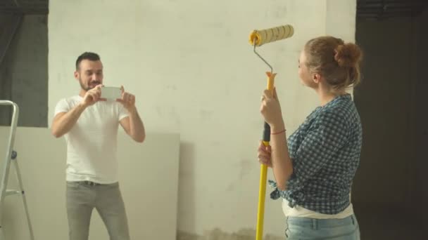 Mannen gör ett foto av kvinnan med roller — Stockvideo