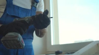 Builder screws the screws into the board, close up