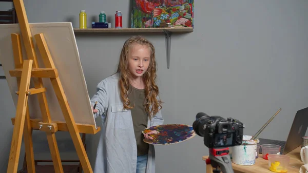 Girl makes a video as she paints a picture