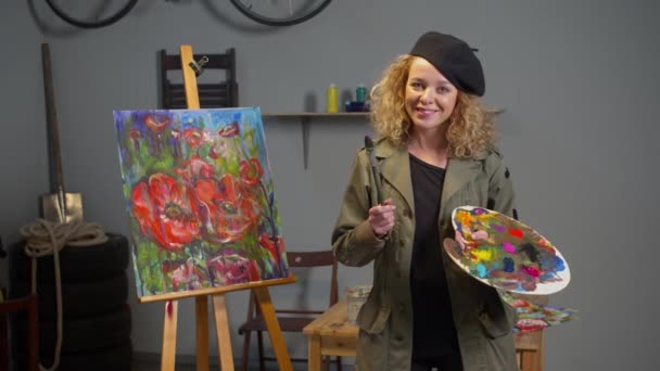 Painter with palette stands and smiles, slow motion — ストック動画