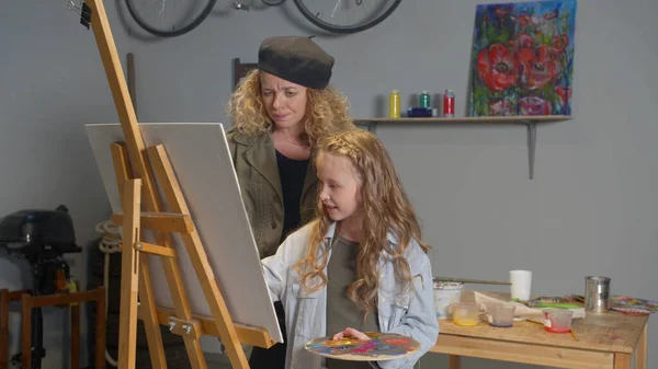 Woman controls the drawing process of a girl — Stock Photo, Image