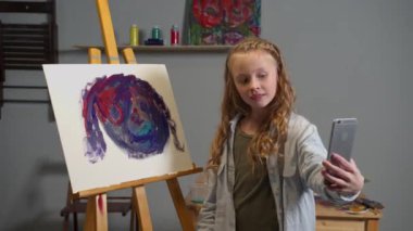 Girl takes a selfie with her picture