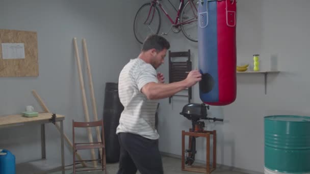 Медленное движение, человек, практикующий трюки на боксерской груше — стоковое видео