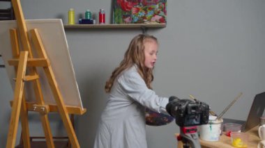 Girl makes a video as she paints a picture