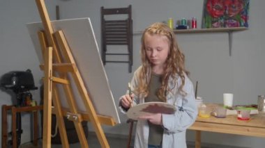 Girl emotionally draws a picture in the studio
