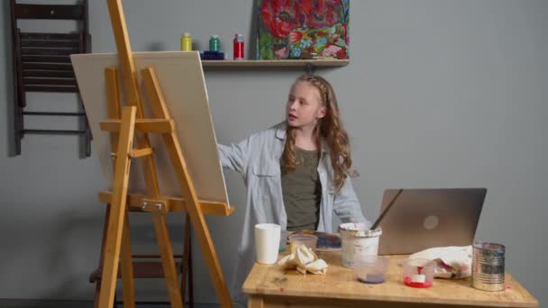Девушка перерисовывает картинку с ноутбука — стоковое видео
