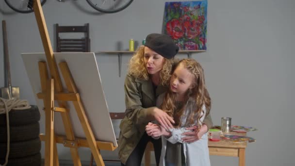 Artist hugs a girl and explains how to draw — Stockvideo